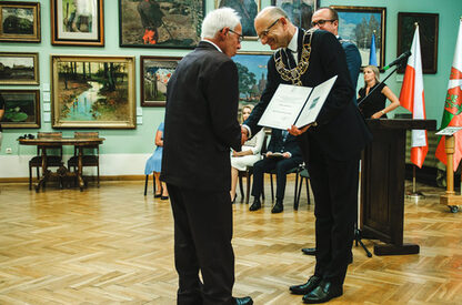 Stadtpräsident Krzysztof Żuk (rechts) übergibt die Jubiläumsmedaille an Ratsherr Dr. Michael Adam, halb verdeckt dahinter der Vorsitzende des Rats der Stadt Lublin, Piotr Kowalczyk (Bild: Jarosław Dudziak).