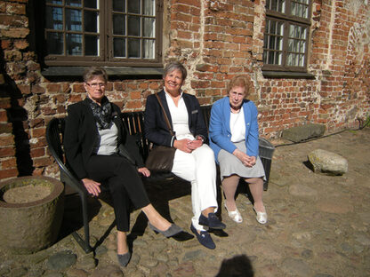 Ratsfrau Margret Hantke (links) und Partnerschaftskreis-Vorsitzende Käthe Stüve (rechts) mit Fachbereichsleiterin Helle Thiele, die im vorigen Jahr in Delmenhorst zu Gast war, im Schlosshof (Bild: Stadt)