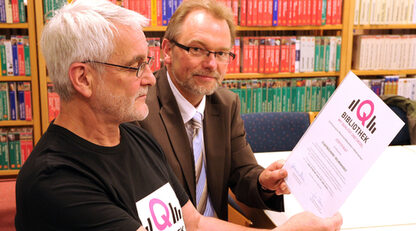 Büchereileiter Günther Wetzig (links) und Fachbereichsleiter Arnold Eckardt präsentieren stolz das Zertifikat der Landesregierung (Bild: Stadt).