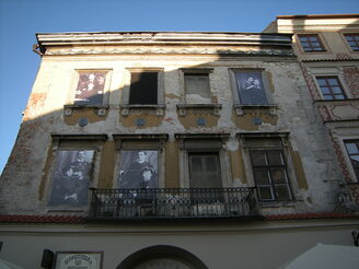 Manche alten Häuser sind noch nicht saniert. Die Fenster leerstehender Gebäude hat die Stadt zum Teil mit historischen Fotos und Bildern bestückt.